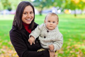 Young mother smiling and holding baby 