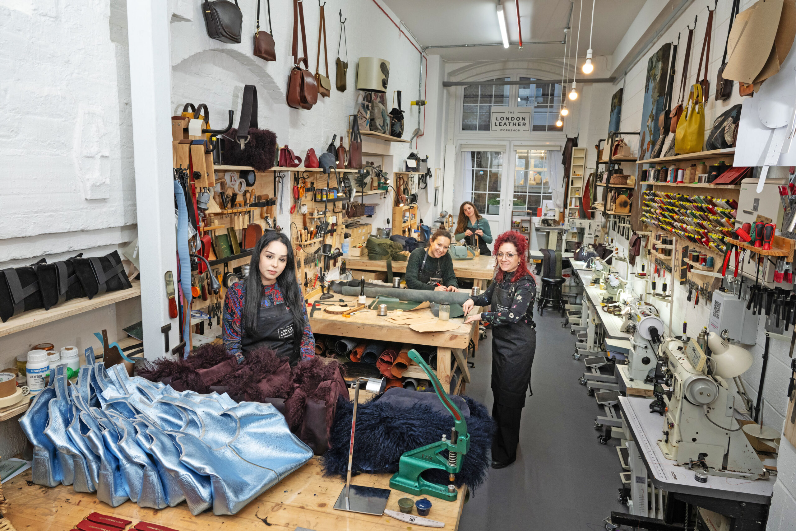 The London Leather Workshop - SE18 View of inside London Leather workshop with 4 workers smiling at camera