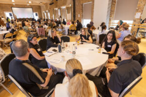 Adults and young people around a table discussing youth employment issues. 