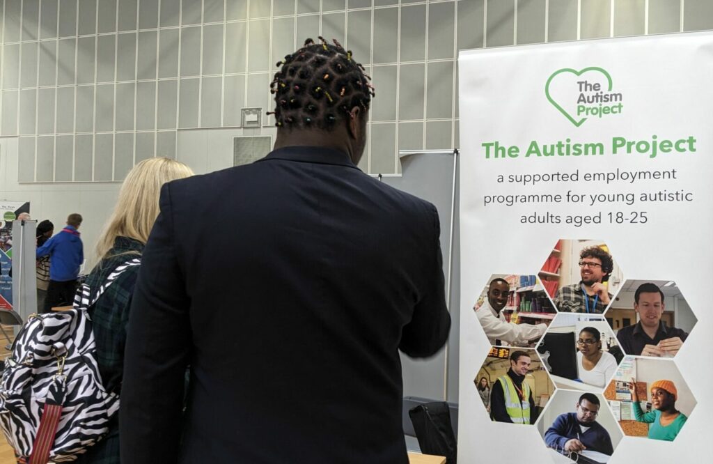 Students speaking to people at The Autism Project stand about supported opportunities